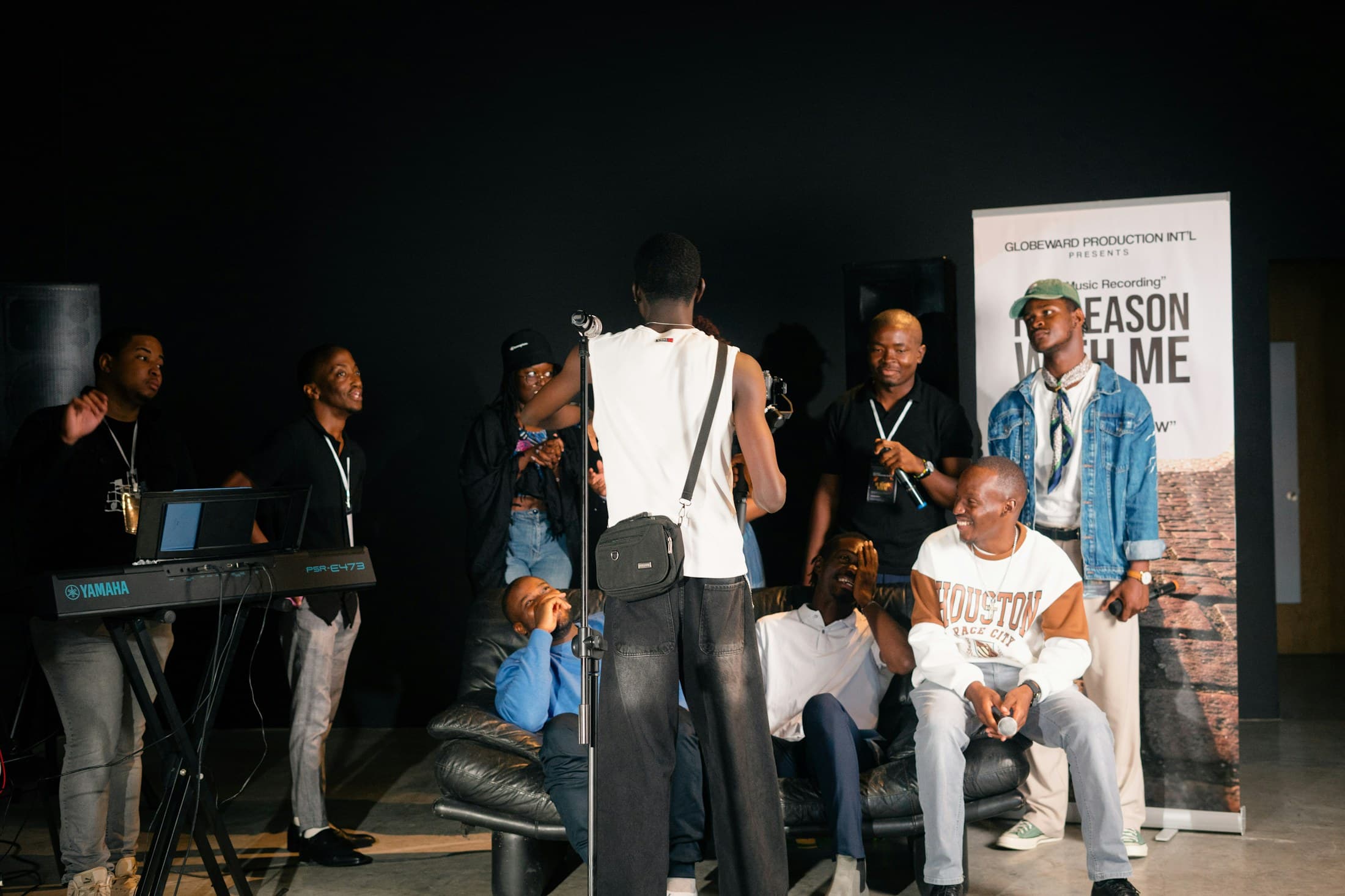 A group of performers preparing together near a stage